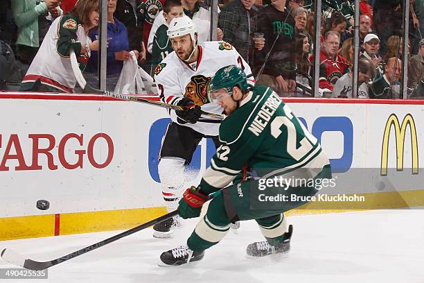 Brent Seabrook of the Chicago Blackhawks passes the puck with Nino Niederreiter of the Minnesota Wild defending during Game Four of the Second Round...