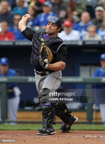 Michael McKenry of the Colorado Rockies throws to third to get the out on Mike Moustakas of the Kansas City Royals who was trying to steal in the...