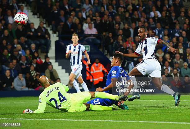 Saido Berahino of West Bromwich Albion beats goalkeeper Tim Howard and Tyias Browning of Everton to score their first goal during the Barclays...