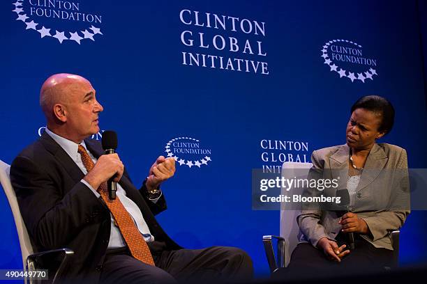 Hugh Grant, chairman and chief executive officer of Monsanto Co., left, speaks as Sylvia Magezi, Uganda program leader of HarvestPlus, listens during...