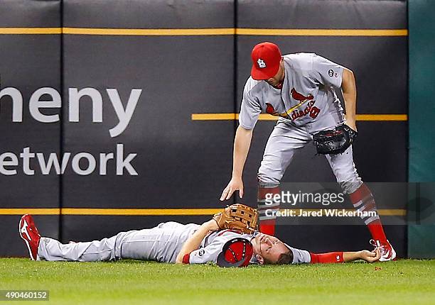 Stephen Piscotty of the St Louis Cardinals lays on the ground while teammate Peter Bourjos waits for the medical staff after colliding on a sliding...
