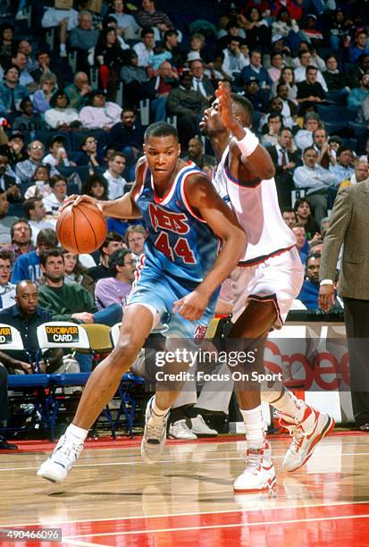 Derrick Coleman of the New Jersey Nets drives on Harvey Grant of the Washington Bullets during an NBA basketball game circa 1991 at the Capital...