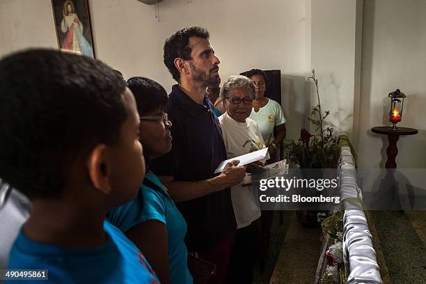 Henrique Capriles, governor of the state of Miranda and a former presidential candidate in the last two elections, center, visits a Catholic church...