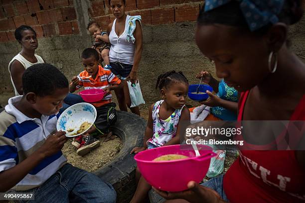 Residents eat soup during a free lunch sponsored by Henrique Capriles, governor of the state of Miranda and a former presidential candidate in the...