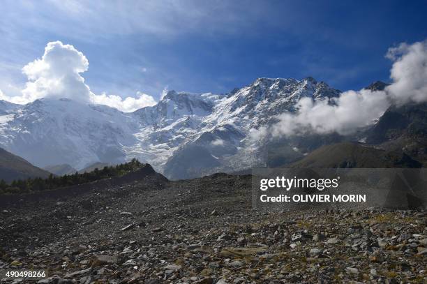 People walk on the Belvedere Glacier on September 26, 2015 on the Monte Rosa. The Belvedere Glacier is a valley glacier, mostly covered by rocks,...