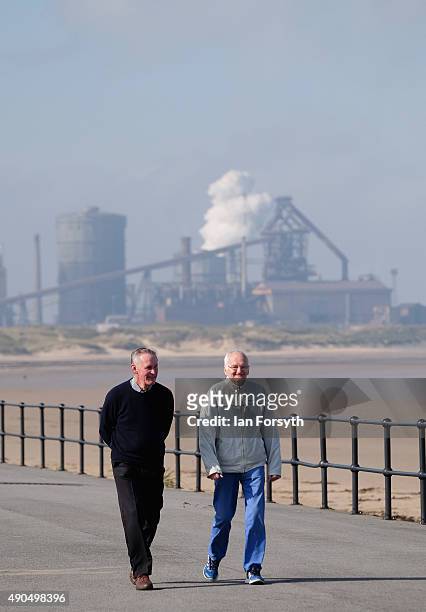 Two men walk along the seafront next to the blast furnace of SSI UK steel on September 29, 2015 in Redcar, England. Following the announcement by SSI...