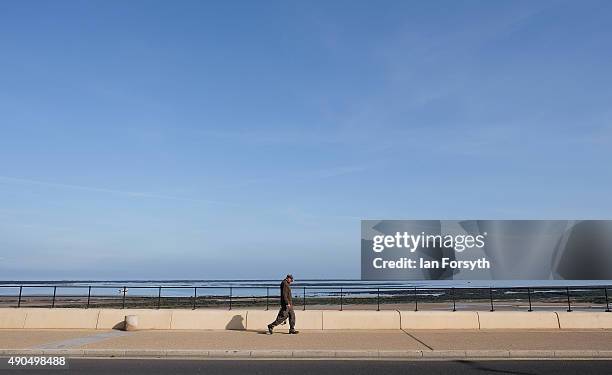 Man walks alongside the seawall on Redcar seafront on September 29, 2015 in Redcar, England. Following the announcement by SSI UK that the steel...
