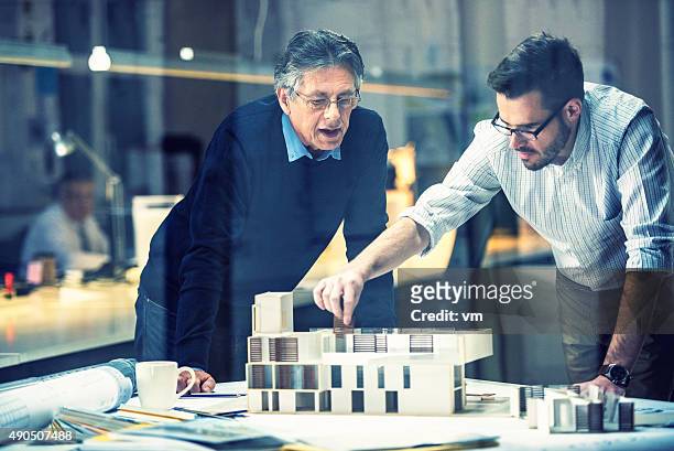 zwei architekten diskutieren neues projekt - architekturberuf stock-fotos und bilder