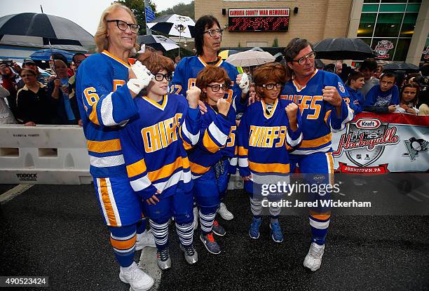 The Hanson Brothers, Dave Hanson, Steve Carlson and Jeff Carlson pose with young hockey fans outside the Cambria County War Memorial Arena before the...