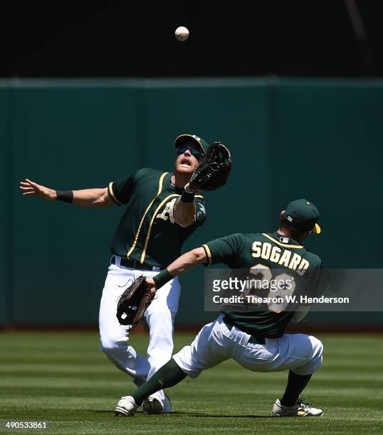 Craig Gentry of the Oakland Athletics avoids colliding with Eric Sogard while catching a fly ball off the bat of Alexei Ramirez of the Chicago White...