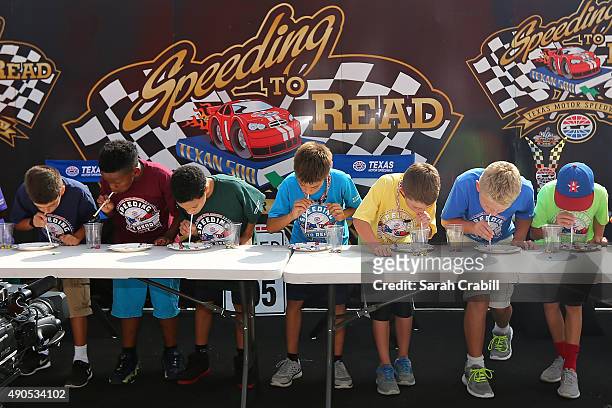 Student participate in a Minute-To-Win-It game during the Speeding To Read Kickoff Assembly at Texas Motor Speedway on September 29, 2015 in Fort...