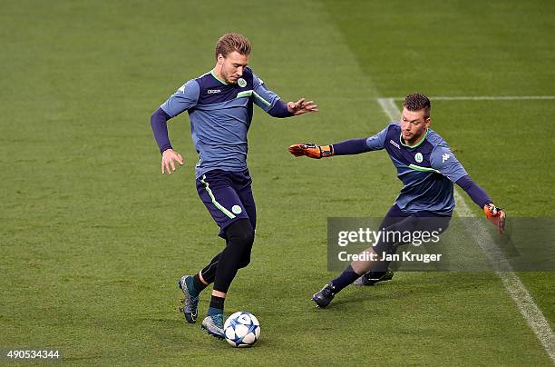 Nicklas Bendtner competes with Max Grun during a VfL Wolfsburg training and press conference ahead of their Champions League fixture against...