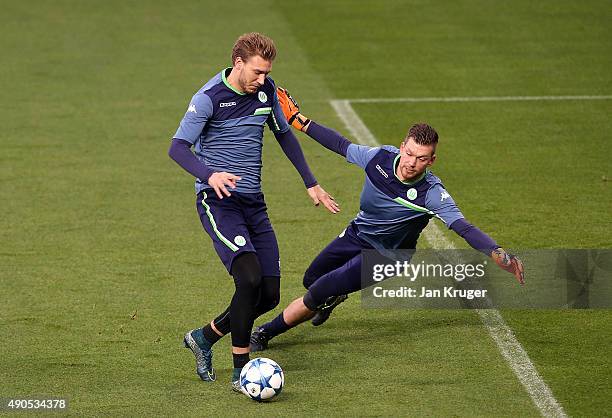 Nicklas Bendtner competes with Max Grun during a VfL Wolfsburg training and press conference ahead of their Champions League fixture against...