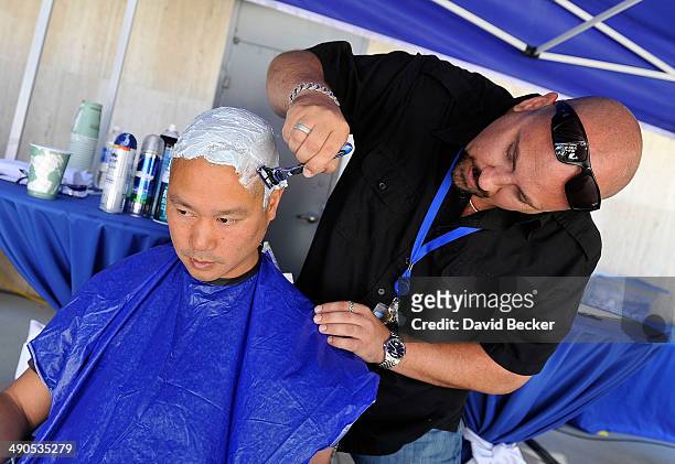 Zappos.com CEO Tony Hsieh has his head shaved by Loren Becker before the unveiling of the "ShoeZaphone" during the annual Bald and Blue fundraiser at...