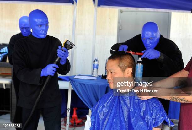 Zappos.com CEO Tony Hsieh pretends to have his head cut by members of Blue Man Group before the unveiling of the "ShoeZaphone" during the annual Bald...