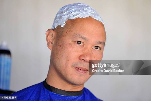 Zappos.com CEO Tony Hsieh's head is prepped with shaving cream before being shaved during the annual Bald and Blue fundraiser at Zappos headquaters...