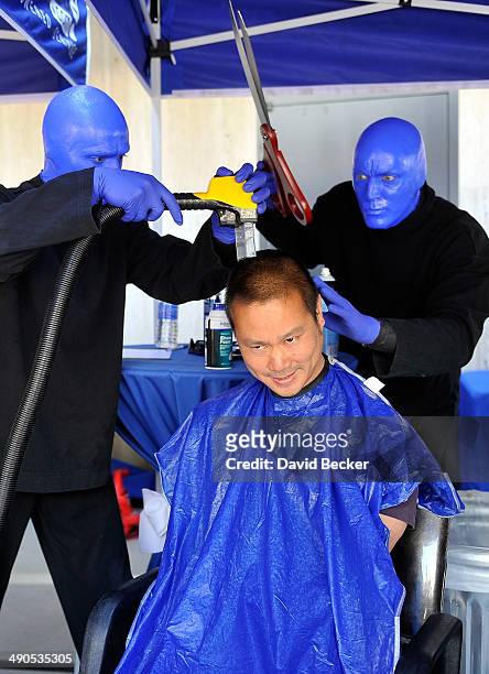 Zappos.com CEO Tony Hsieh pretends to have his head cut by members of Blue Man Group before the unveiling of the "ShoeZaphone" during the annual Bald...