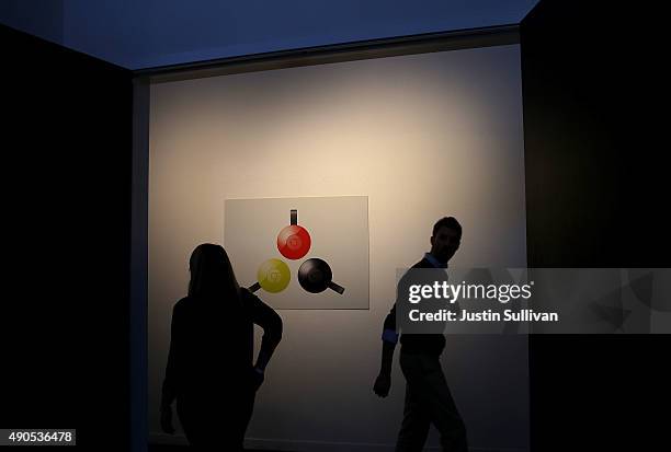 Attendees walk by a poster with an image of the new Google Chromecast during a Google media event on September 29, 2015 in San Francisco, California....