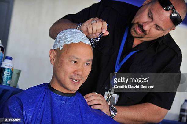 Zappos.com CEO Tony Hsieh has his head shaved by Loren Becker before the unveiling of the "ShoeZaphone" during the annual Bald and Blue fundraiser at...