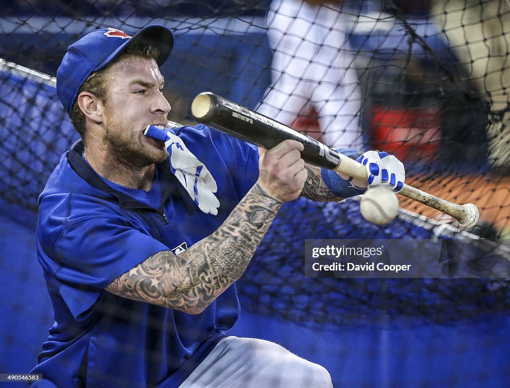 Toronto Blue Jays  Brett Lawrie (13) steps in to the cage  with one batting glove in his mouth while taking bunts