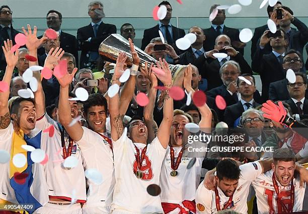 Sevilla's Croatian midfielder Ivan Rakitic raises the Europa league trophy among teammates after winning the UEFA Europa league final football match...