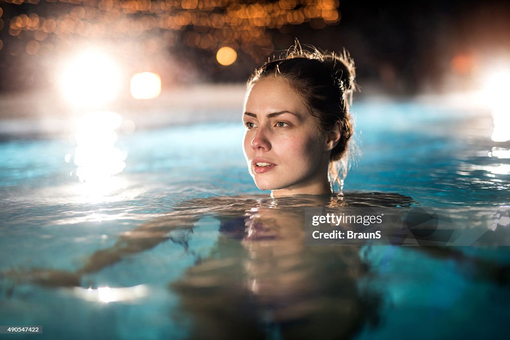 Nachdenklich Frau im beheizten Swimmingpool im Freien.