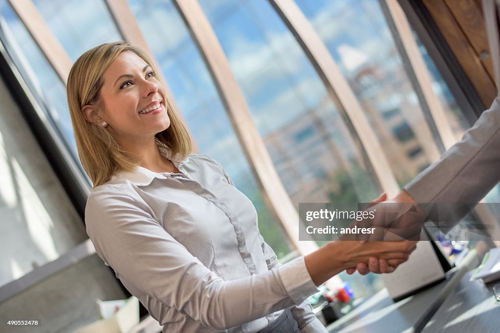Business woman greeting a client at the office