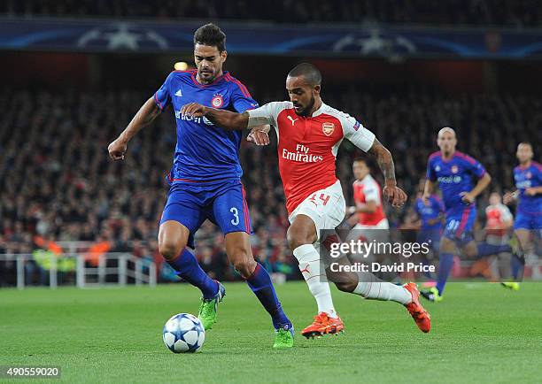 Theo Walcott of Arsenal takes on Alberto Botia of Olympiacos during the match between Arsenal and Olympiacos on September 29, 2015 in London, United...