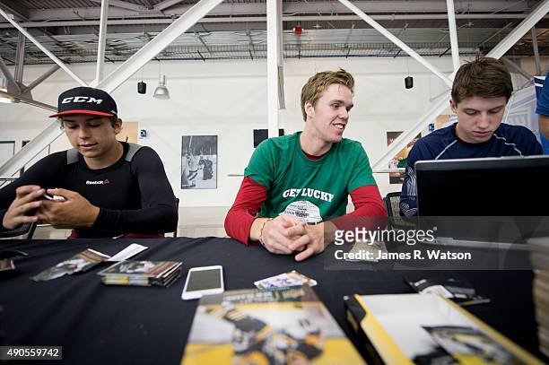 Dylan Strome of the Arizona Coyotes, Connor McDavid of the Edmonton Oilers and Mitch Marner of the Toronto Maple Leafs open hockey card packs at the...