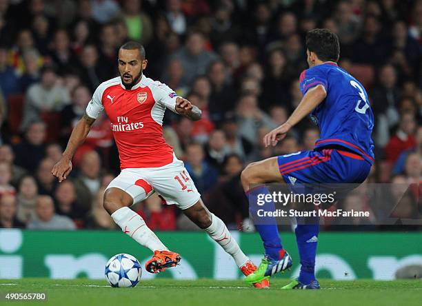 Theo Walcott of Arsenal takes on Alberto Botia of Olympiacos during the UEFA Champions League match between Arsenal and Olympiacos at Emirates...