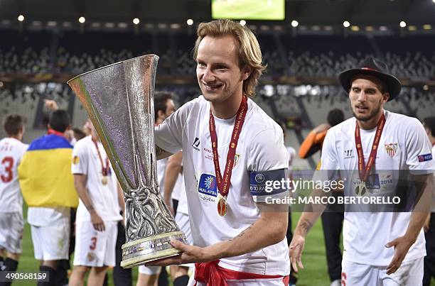 Sevilla's Croatian midfielder Ivan Rakitic poses with the trophy after winning the UEFA Europa league final football match between Benfica and...