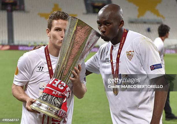 Sevilla's French forward Kevin Gameiro and Sevilla's Cameroonian midfielder Stephane Mbia celebrate with the trophy after winning the UEFA Europa...
