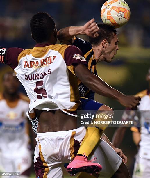 Footballer Julian Quinonez of Colombia's team Deportes Tolima and Guido Di Vanni of Paraguay's Sportivo Luqueno vie for the ball during a...