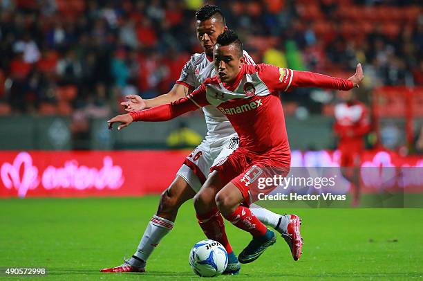 Christian Cueva of Toluca struggles for the ball with Michael Orozco of Tijuana during the 11th round match between Toluca and Tijuana as part of the...