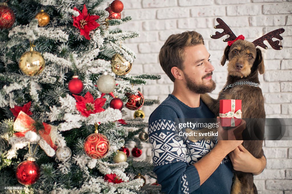 Man with his dog hugging for christmas.