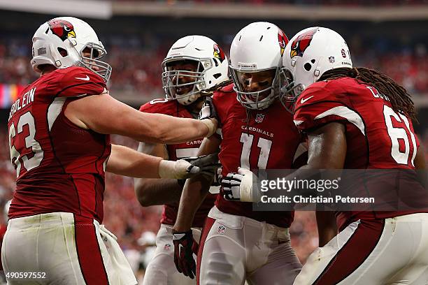 Wide receiver Larry Fitzgerald of the Arizona Cardinals celebrates with Lyle Sendlein and Jonathan Cooper after catching a touchdown reception...