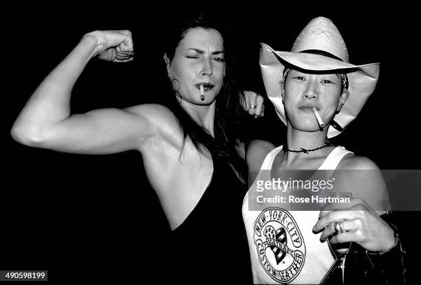 Models Carre Otis and Jenny Shimuzu vamp it up during Vogue Magazine's 'Snaps' party at an unidentified Soho loft, New York, New York, 1990s.