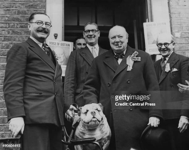 British Conservative Party leader Winston Churchill with a bulldog mascot as he leaves the Wanstead Conservative Club in his Woodford, Essex,...