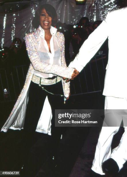 Bobby Brown leads singer Whitney Houston by the hand at the Costume Institute gala at the Metropolitan Museum, New York, New York, 1999.