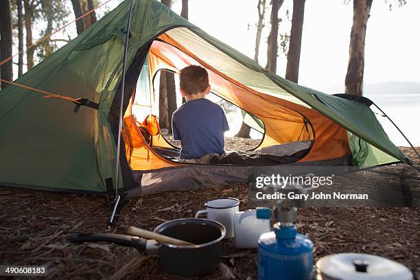 young boy sitting alone in tent - camping imagens e fotografias de stock