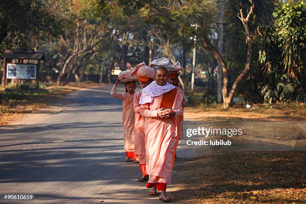 young nuns queuing up for food or other donations. - buddist nun stock pictures, royalty-free photos & images