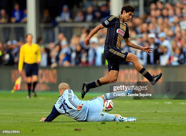 Aurelien Collin of Sporting KC slides for the ball as Cristian Maidana of Philadelphia Union leaps over during the game at Sporting Park on May 14,...