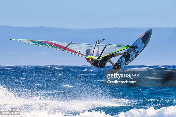 man jumping wave on windsurf board - windsurf stock pictures, royalty-free photos & images