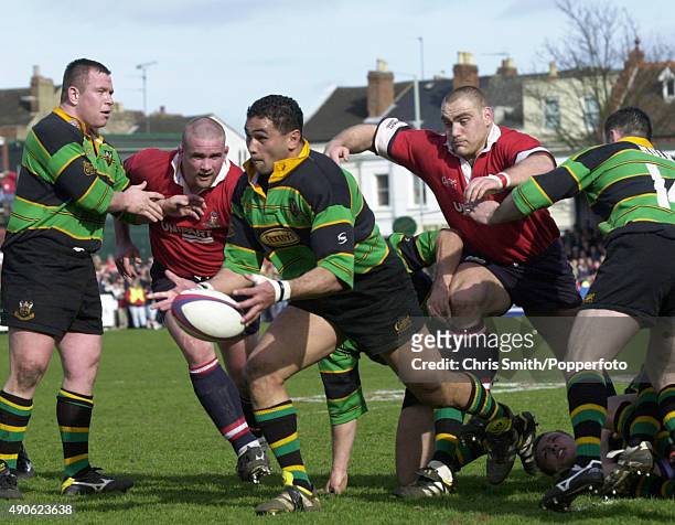Pat Lam of Northampton Saints passes the ball watched by Phil Vickery and Trevor Woodman of Gloucester during the Allied Dunbar Premiership match at...