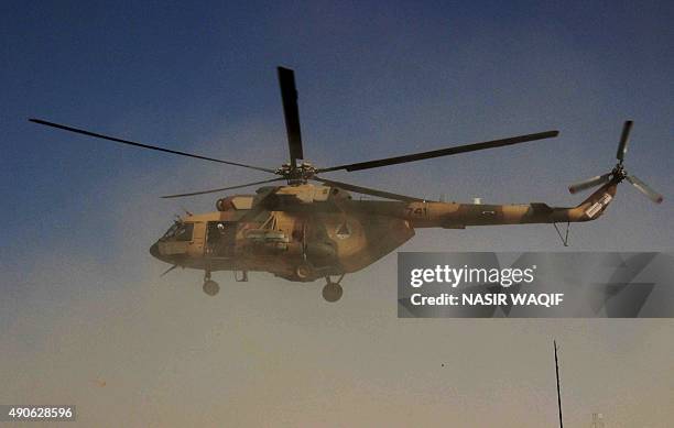 An Afghan helicopter carrying security personnel arrives at the scene of an offensive against Taliban insurgents in Kunduz on September 30, 2015....