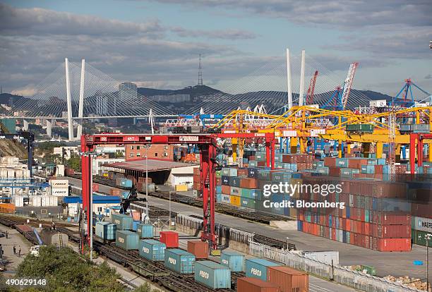 Shipping containers sit on freight wagons beside the dock storage area at the Commercial Port of Vladivostok in Vladivostok, Russia, on Saturday,...