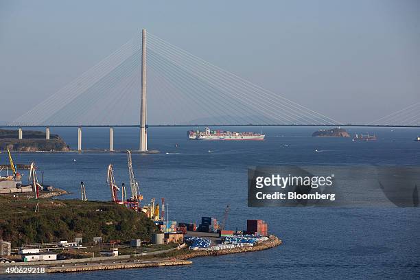 China Ocean Shipping Group Co. Container ship passes the Russian bridge across the Eastern Bosphorus strait in Vladivostok, Russia, on Saturday,...