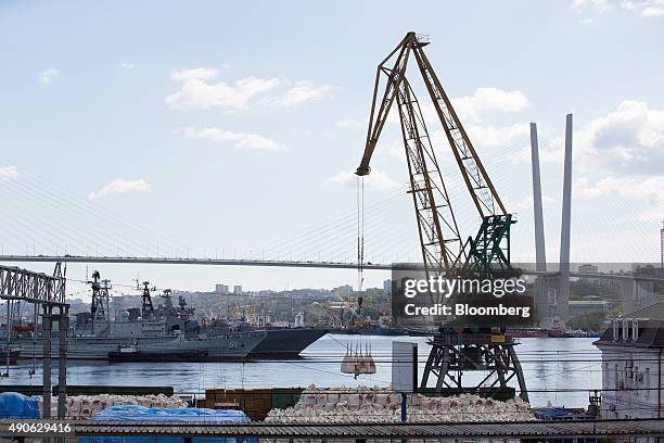 Russian warships sit beyond a crane operating on the dockside in the harbor at Golden Horn Bay in Vladivostok, Russia, on Monday, Sept. 28, 2015. "It...