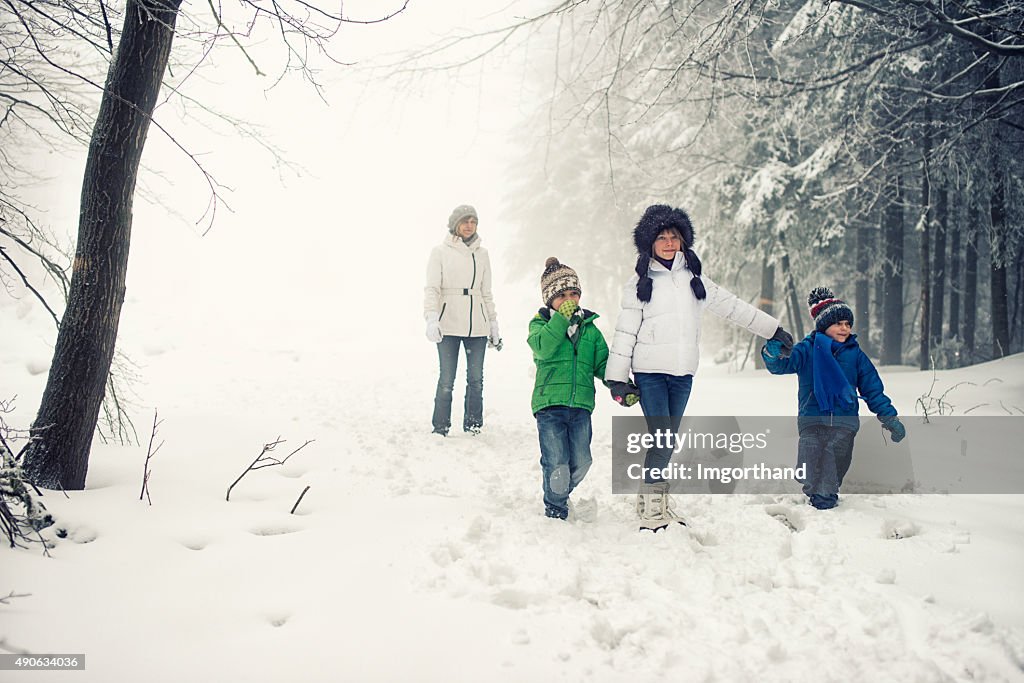 Family enjoying winter walk in forest.