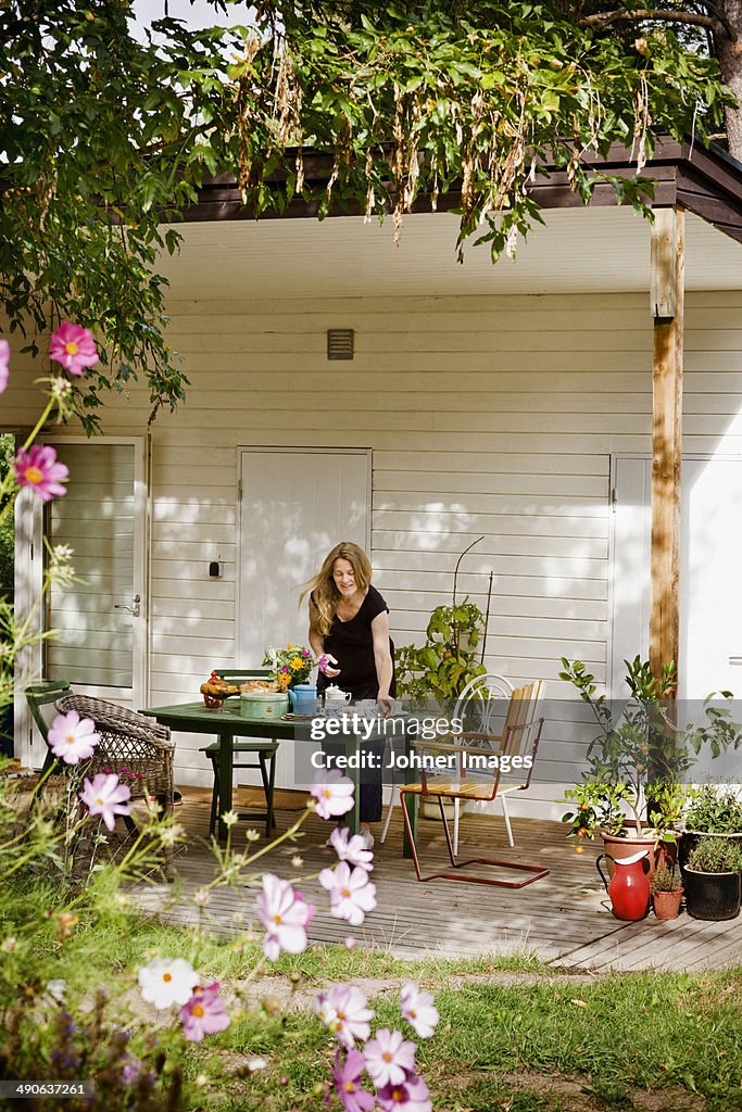 Woman setting table on porch